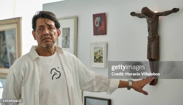 Collection owner Claudio Pereira briefs journalists on a patinated bronze Christ by Alfredo Ceschiatti during a press visit to "Brasilia - From...