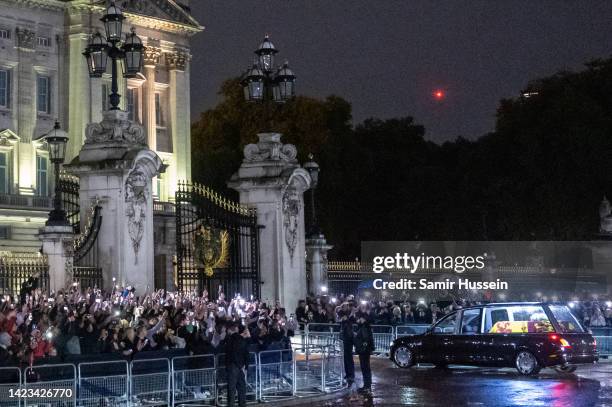 The hearse carrying the flag-draped casket of Queen Elizabeth II arrives at Buckingham Palace on September 13, 2022 in London, England. Queen...