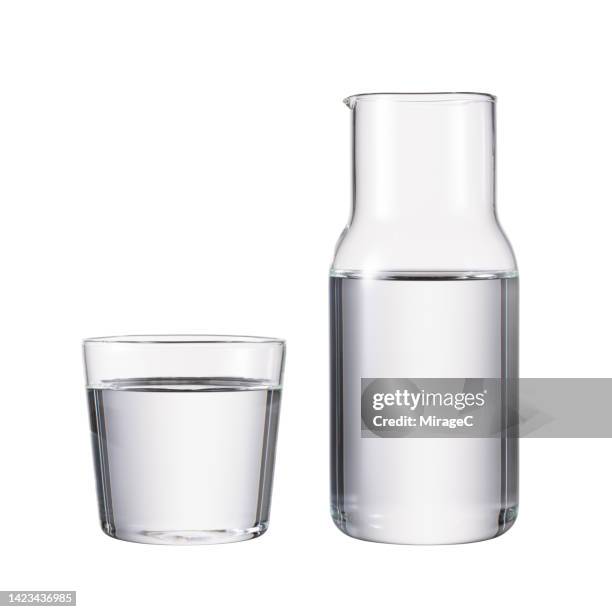 glass water pitcher with drinking glass full of water isolated on white - jug stock pictures, royalty-free photos & images