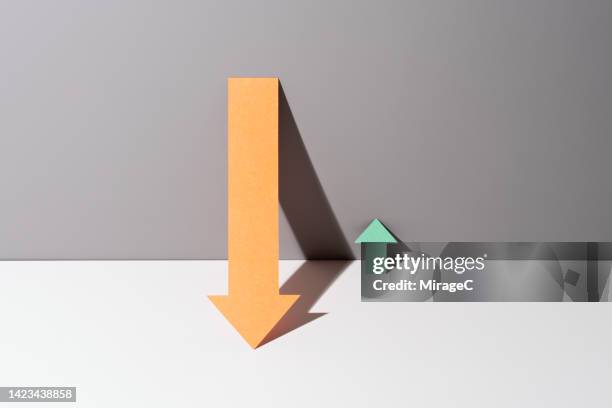 disparity between huge reduction arrow and tiny growth arrow - micro finance stock pictures, royalty-free photos & images