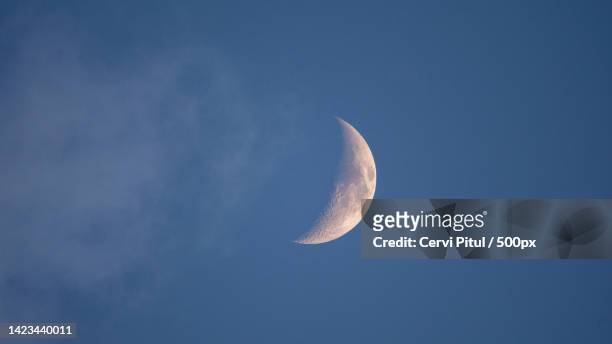 low angle view of moon against clear blue sky - crescent foto e immagini stock