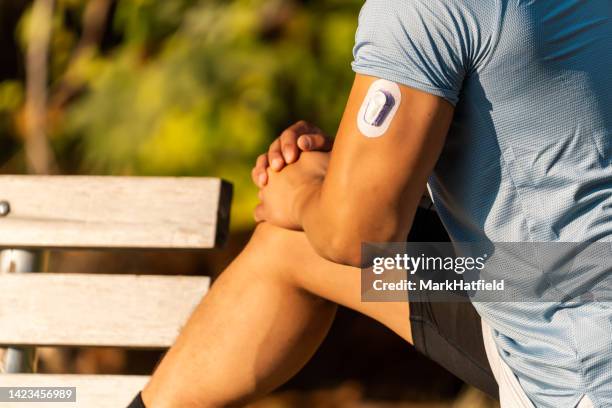athlete stretching with continuous glucose monitor transmitter - continuous glucose monitor stock pictures, royalty-free photos & images