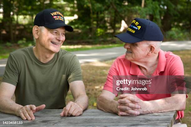 guerra de corea y veterano de vietnam sonriendo mirándose el uno al otro - war veteran fotografías e imágenes de stock