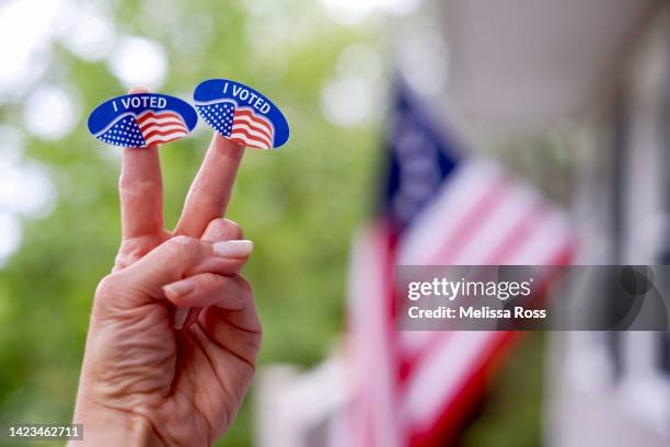 fingers holding up i voted stickers. - élections présidentielles des états unis photos et images de collection