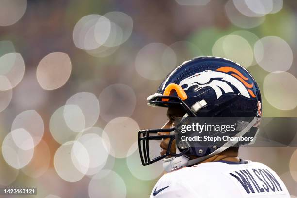 Russell Wilson of the Denver Broncos looks on as fans illuminate their cellphones during the fourth quarter against the Seattle Seahawks at Lumen...