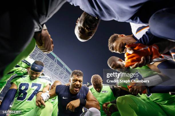 Russell Wilson of the Denver Broncos leads teams in prayer following a game between the Seattle Seahawks and the Denver Broncos at Lumen Field on...