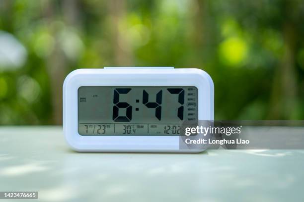 an electronic alarm clock on the desk - orologio digitale foto e immagini stock