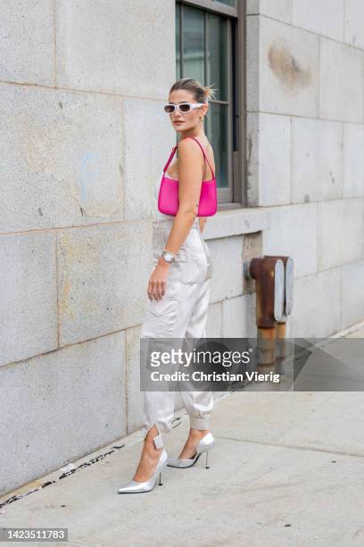 Guest wearing creme white pants, white top, pink bag, silver heels outside Gabriela Hearst on September 13, 2022 in New York City.