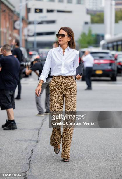 Guest wearing animal print pants, white button shirt outside Gabriela Hearst on September 13, 2022 in New York City.