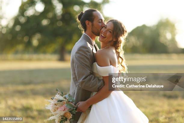 a newlyweds couple posing together in the countryside - wedding couple stock pictures, royalty-free photos & images