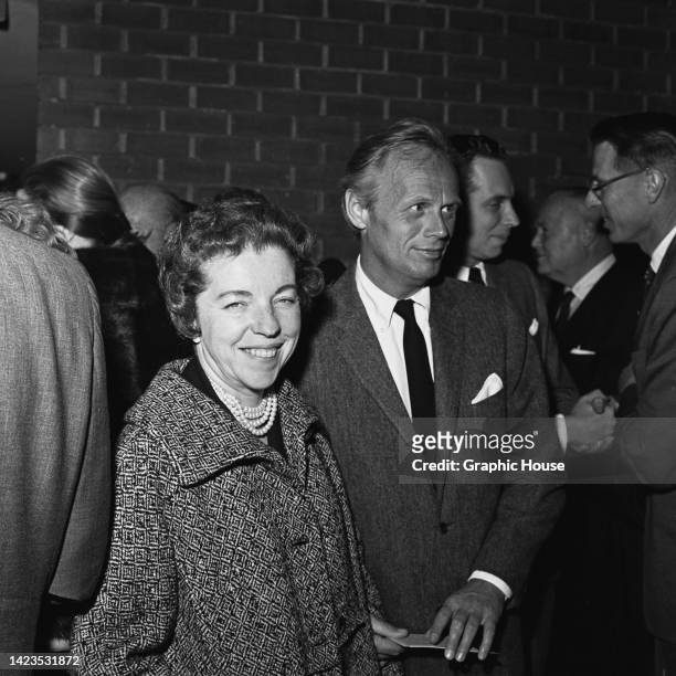 American screenwriter Jean Hazlewood , wearing a tweed coat with a pearl necklace visible beneath, and her husband, American actor Richard Widmark ,...