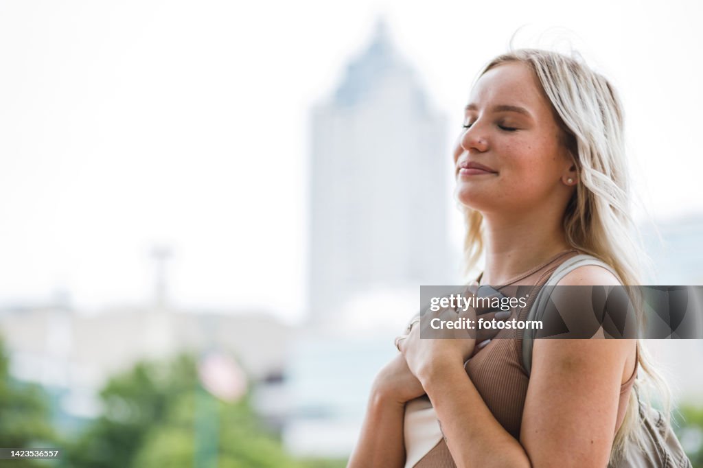 Young woman holding her smart phone close to the heart after receiving a text message