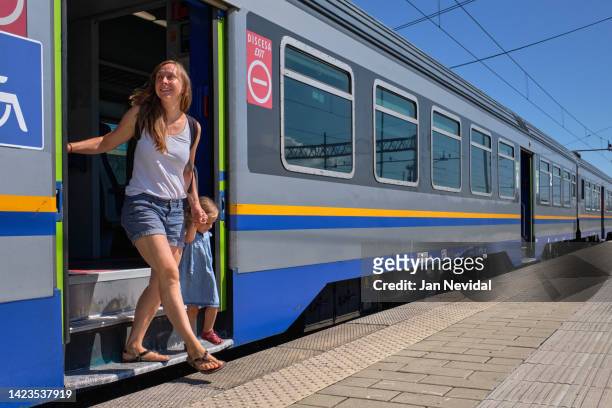 una giovane famiglia sta scendendo da un treno - binario di stazione ferroviaria foto e immagini stock