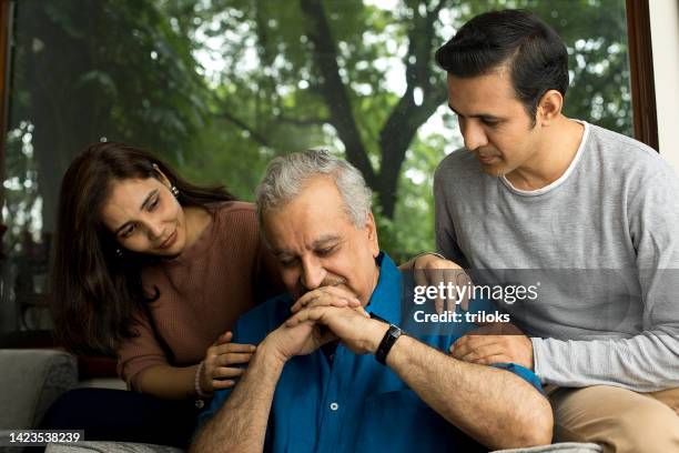 couple comforting depressed old father at home - south asia stock pictures, royalty-free photos & images