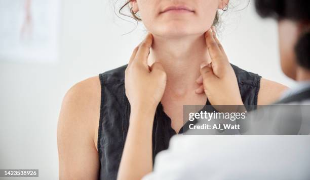 doctor checking thyroid of a young patient in clinic - menselijke nek stockfoto's en -beelden