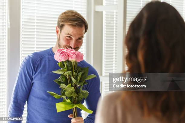 mann, der die rosen riecht, die er seiner liebenden frau geben wird - woman giving flowers stock-fotos und bilder