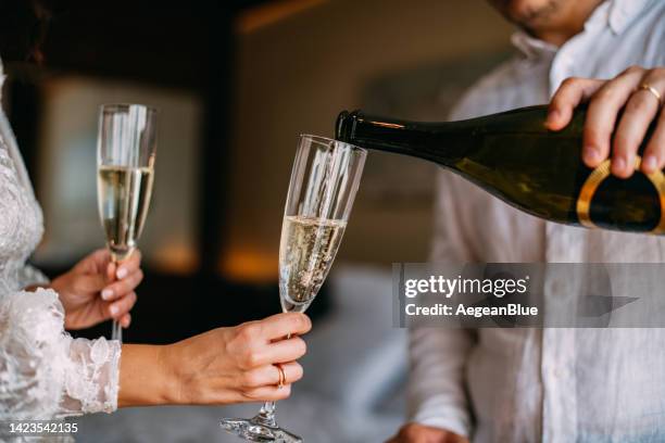 braut und bräutigam feiern ihre hochzeit mit champagner - champagnerglas stock-fotos und bilder