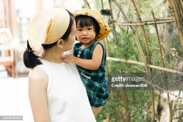 asian young adult mother enjoying leisure with daughter backyard garden homegrown at home sustainable life. - einjährig pflanzeneigenschaft stock-fotos und bilder