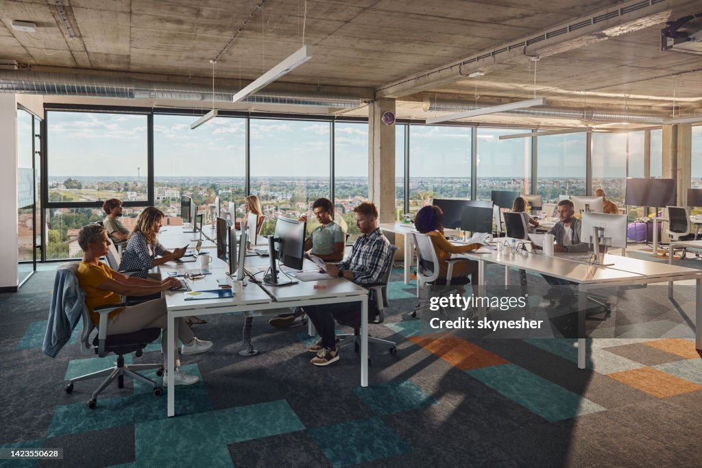 Multitasking-Computerprogrammierer, die in einem modernen Büro arbeiten.