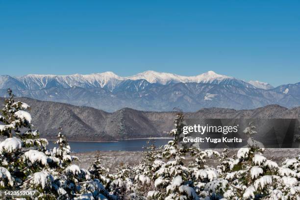 snowy mountains over a lake in winter - minami alps foto e immagini stock