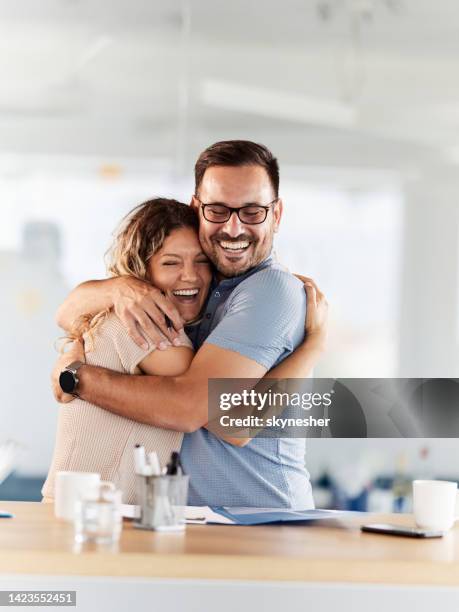 young happy couple celebrating signing a contract with a hug. - couple signing stock pictures, royalty-free photos & images