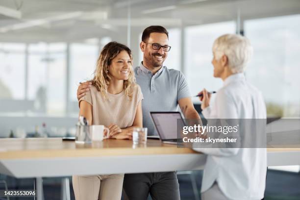 happy couple talking to insurance agent in the office. - bankers imagens e fotografias de stock