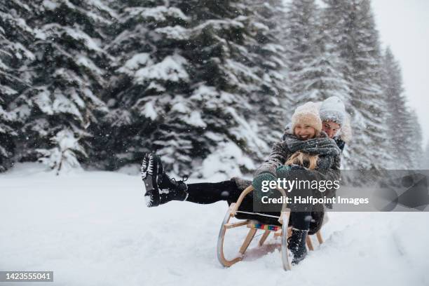 young couple in love sledding in wintery nature under falling snow. - winter couple stock-fotos und bilder