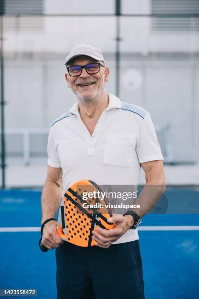 positive senior paddle tennis player - using a paddle imagens e fotografias de stock