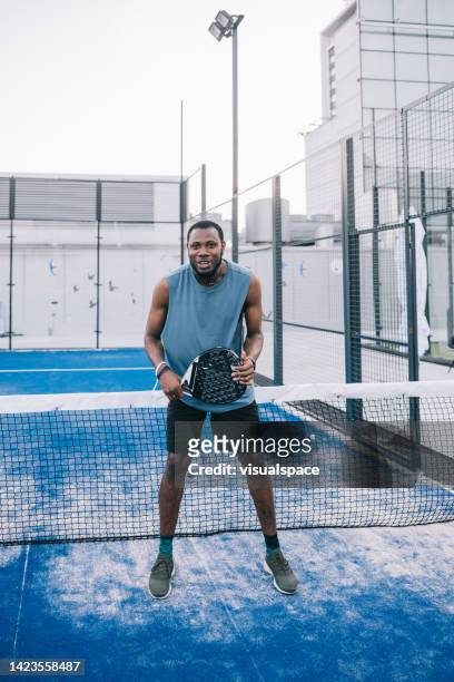 joueur de paddle-tennis positif sur le court sur le toit - paddle tennis photos et images de collection