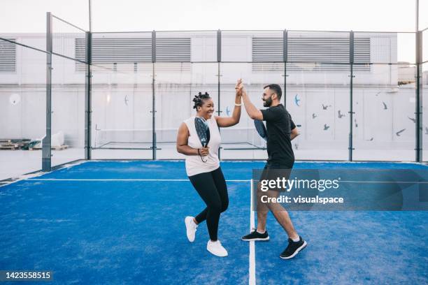 high five for successful paddle tennis match - pudel stock pictures, royalty-free photos & images