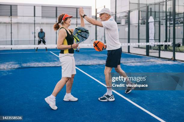 alto cinque per una partita di paddle tennis di successo - paddle tennis foto e immagini stock