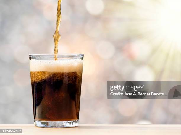 glass of drink with cola illuminated by sunlight. - 冷たい飲み物 ストックフォトと画像