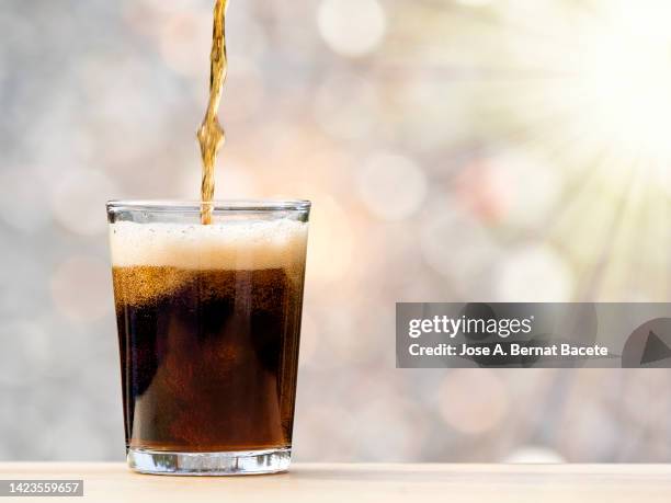 glass of drink with cola illuminated by sunlight. - soda imagens e fotografias de stock