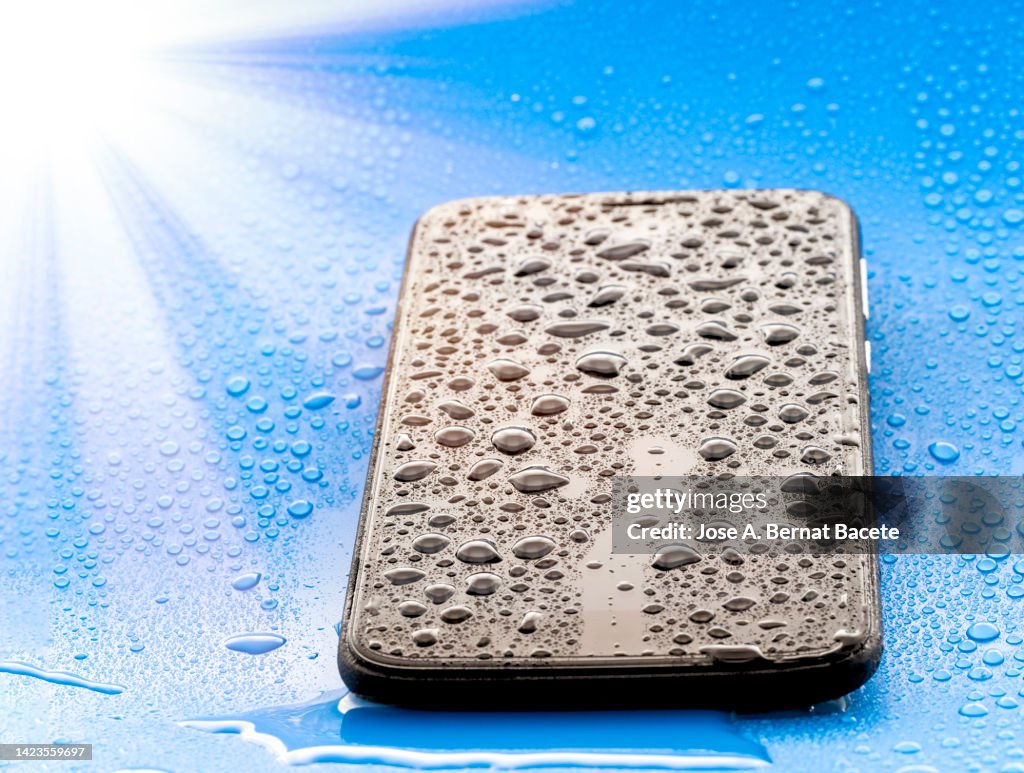 Mobile phone wet from the rain drying in the sun.