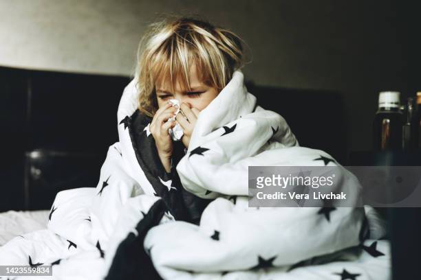 boy get cold and blow her nose at home. - haemophilus influenzae fotografías e imágenes de stock