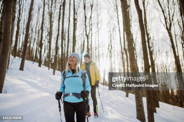 senior couple hiking in winter forest. - active seniors winter stock pictures, royalty-free photos & images