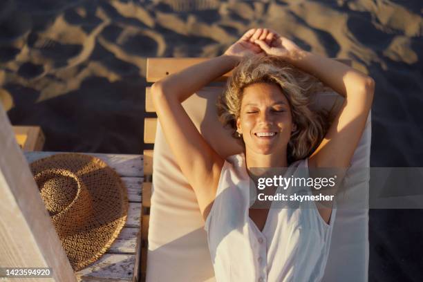vista superior de una mujer feliz relajándose en una tumbona en la playa. - tomar el sol fotografías e imágenes de stock