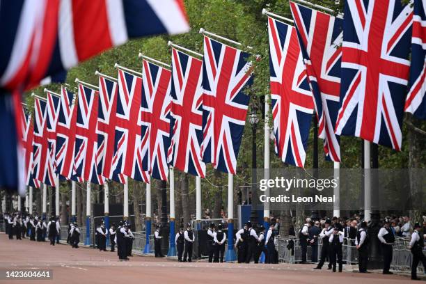Union flags are seen lining The Mall as Metropolitan Police officers gather ahead of the procession for the Lying-in State of Queen Elizabeth II on...