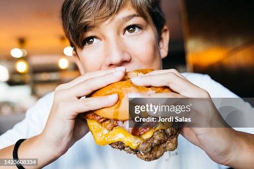 Teenager eating a burger Teenager eating a burger