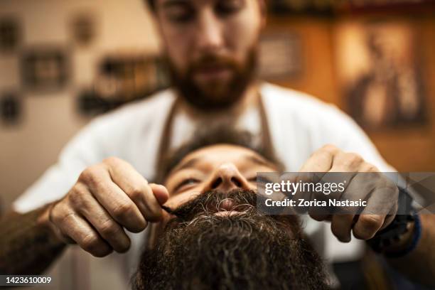 barbiere styling baffi di un cliente in barbiere - moustache foto e immagini stock