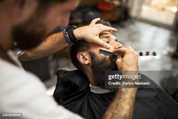 barber using razor blade - barbers stockfoto's en -beelden