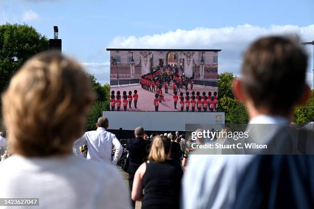 Mourners watch the procession for the Lying-in State of Queen Elizabeth II at the Hyde Park screening site on September 14, 2022 in London, England....