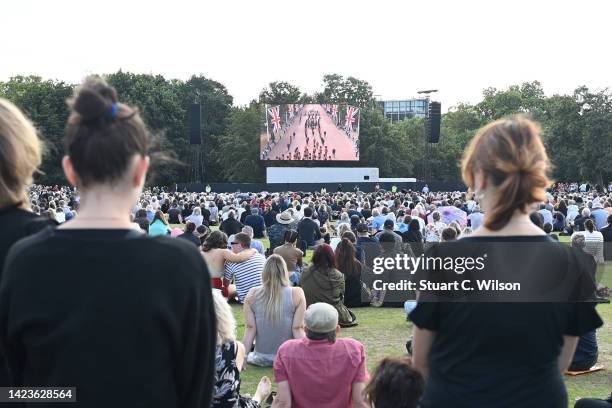 Mourners watch the procession for the Lying-in State of Queen Elizabeth II at the Hyde Park screening site on September 14, 2022 in London, England....