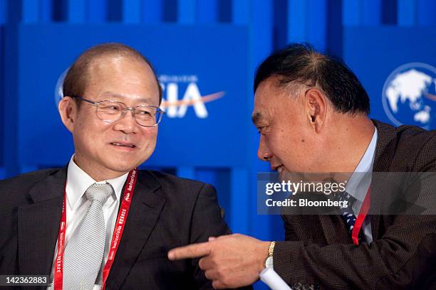 Wang Dongming, chairman of Citic Securities Co. Ltd., right, speaks with Schive Chi, chairman of the Taiwan Stock Exchange Corp., during a session at...