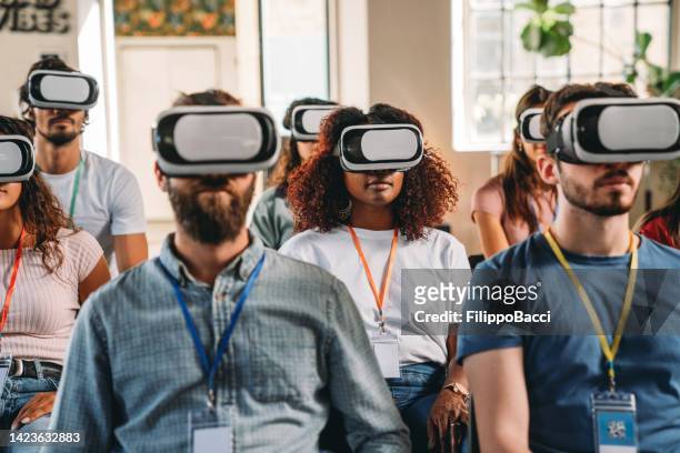 group of people wearing virtual reality vr glasses during a virtual meeting - virtual reality simulator presentation stockfoto's en -beelden