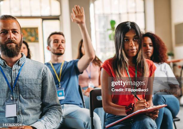 group of people sitting during a meeting - employee badge stock pictures, royalty-free photos & images