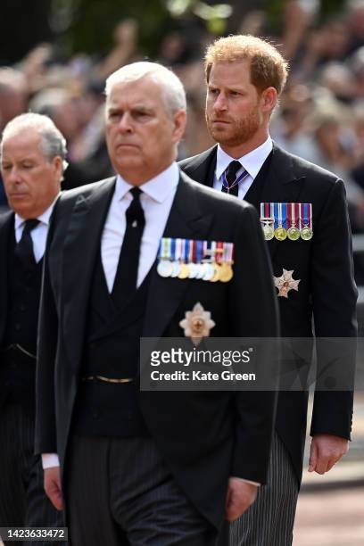 Prince Andrew, Duke of York and Prince Harry, Duke of Sussex walk behind the coffin during the procession for the Lying-in State of Queen Elizabeth...