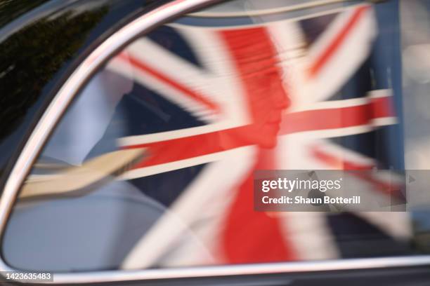Catherine, Princess of Wales's reflection in a car window within the Union Jack flag as she departs the procession for the Lying-in State of Queen...