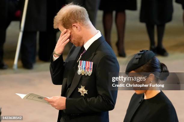 An emotional Prince Harry, Duke of Sussex and Meghan, Duchess of Sussex pay their respects in The Palace of Westminster after the procession for the...