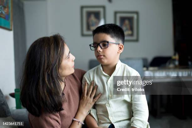 loving mother embracing son at home - south asia stock pictures, royalty-free photos & images